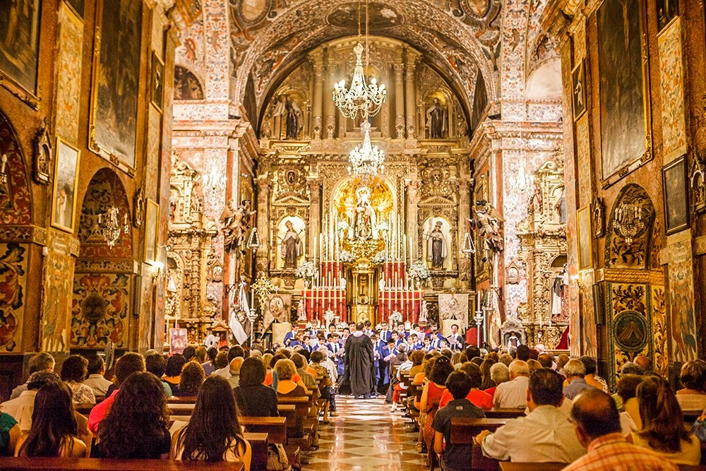 Choir performing infront of ornate spanish altar